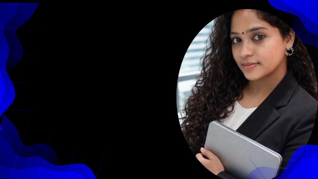 Ambili is standing by holding a laptop on hand